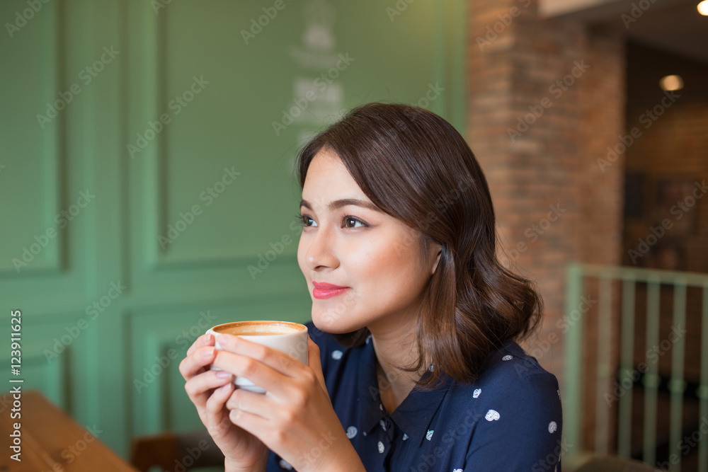 快乐的年轻商业女性的肖像，手里拿着杯子喝酒