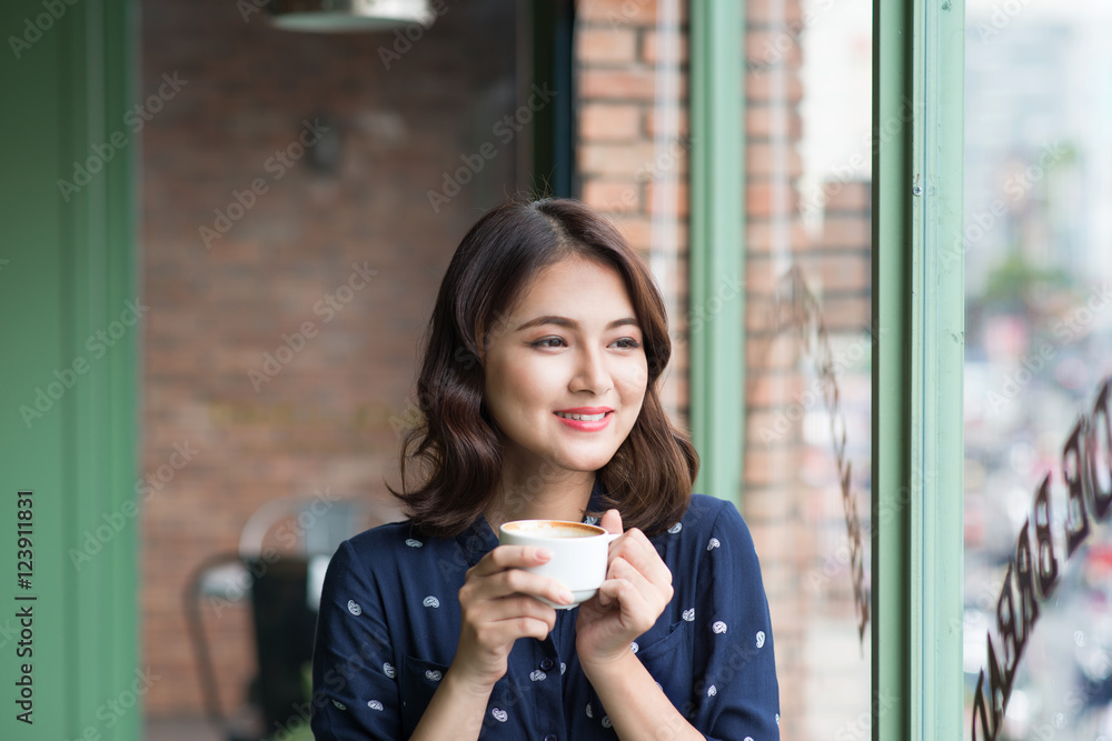 快乐的年轻商业女性的肖像，手里拿着杯子喝酒