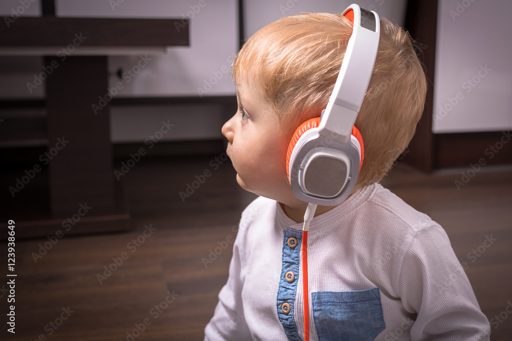 Little boy listening to the music on headphones