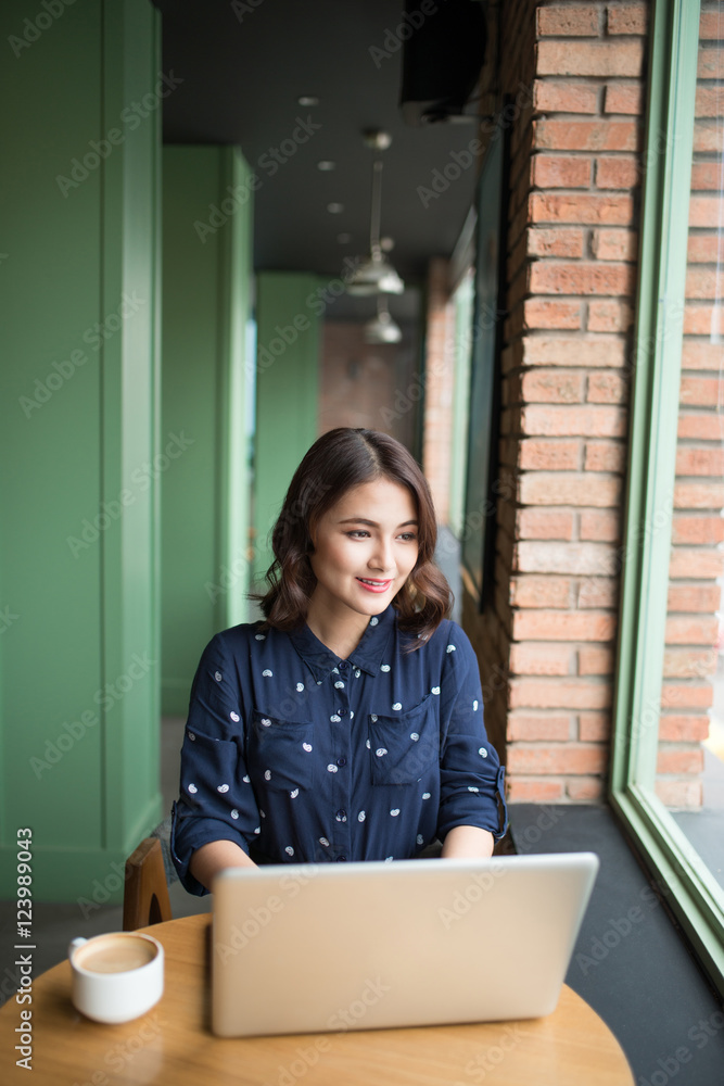 Beautiful cute asian young businesswoman in the cafe, using lapt