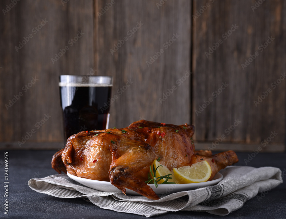 Chicken roasted with glass of drink on table