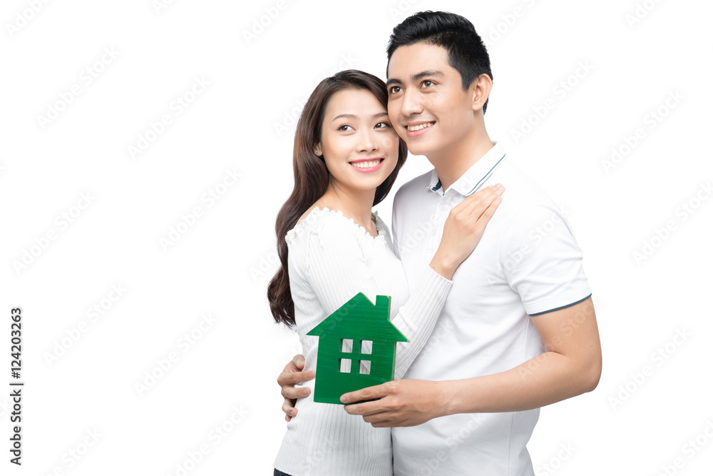 Loan concept. Young couple holding a white miniature house