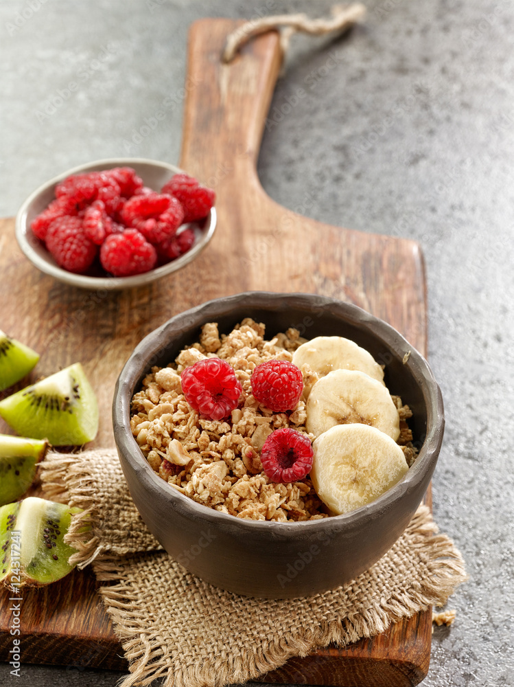 bowl of granola with banana and raspberries