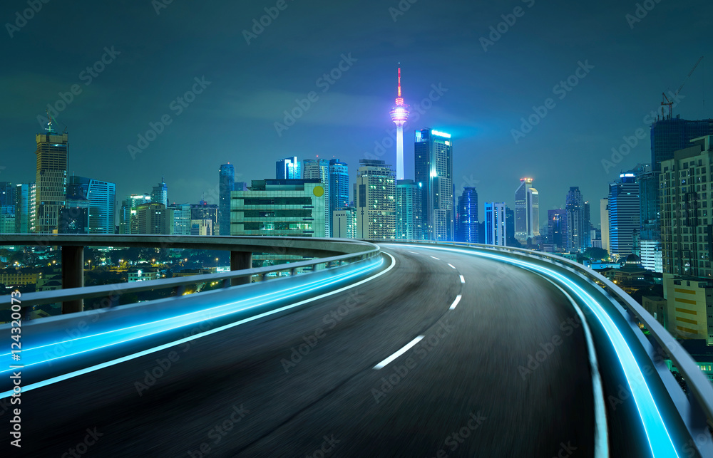 Blue neon light highway overpass motion blur with city  skyline background , night scene .