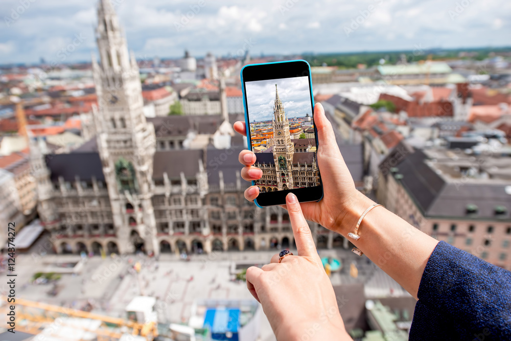 Photographing with smart phone the clock tower of the town hall in Munich city, Germany