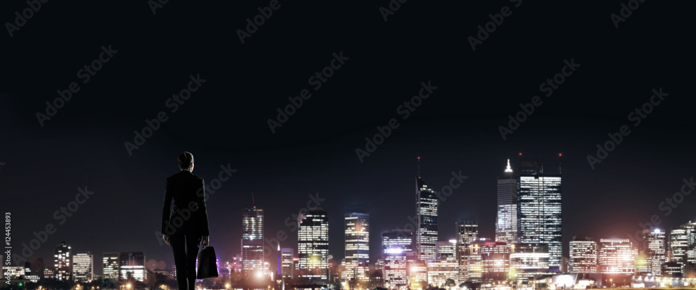 Businesswoman viewing night glowing city