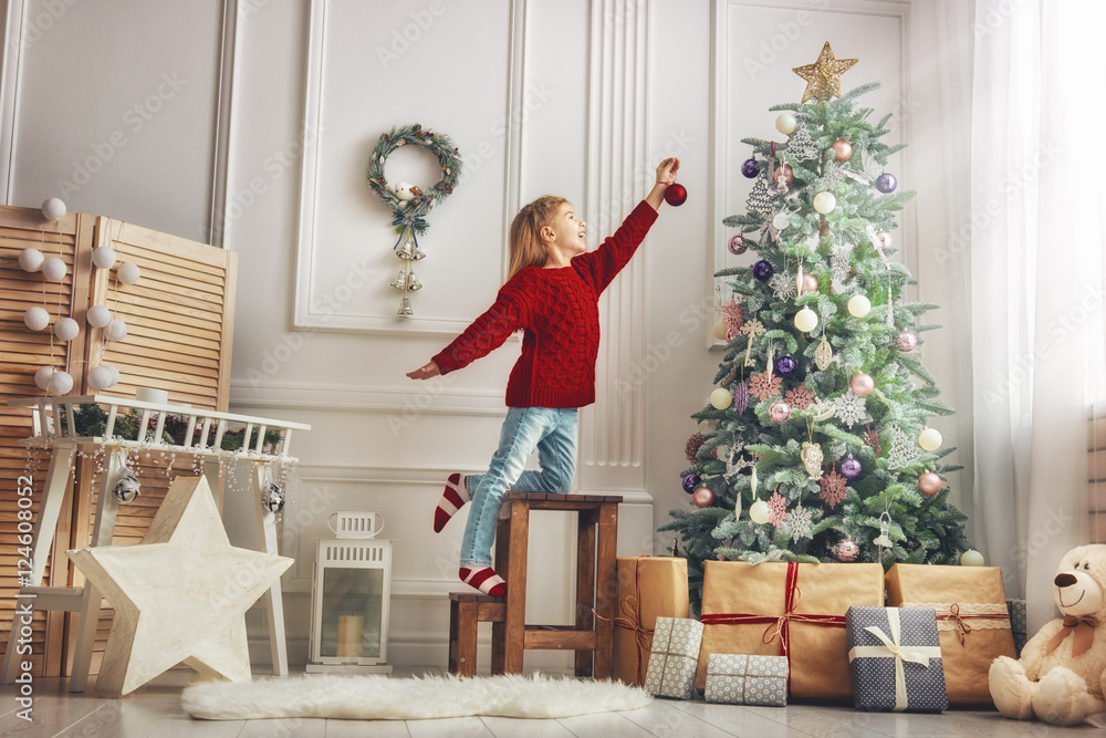 girl is decorating the Christmas tree