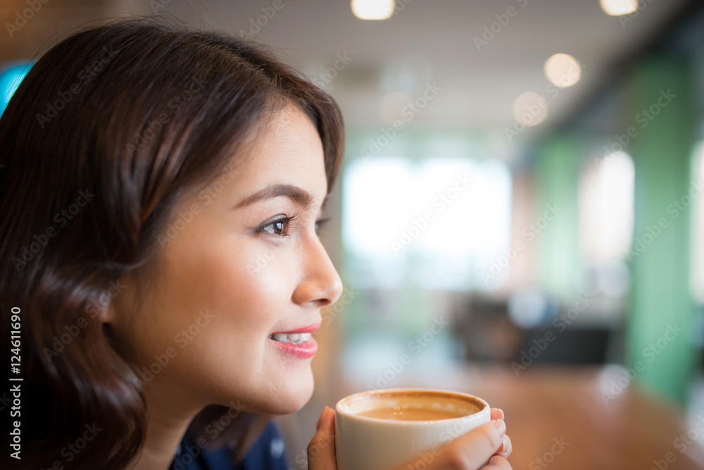 Portrait of attractive young asian woman drinking coffee