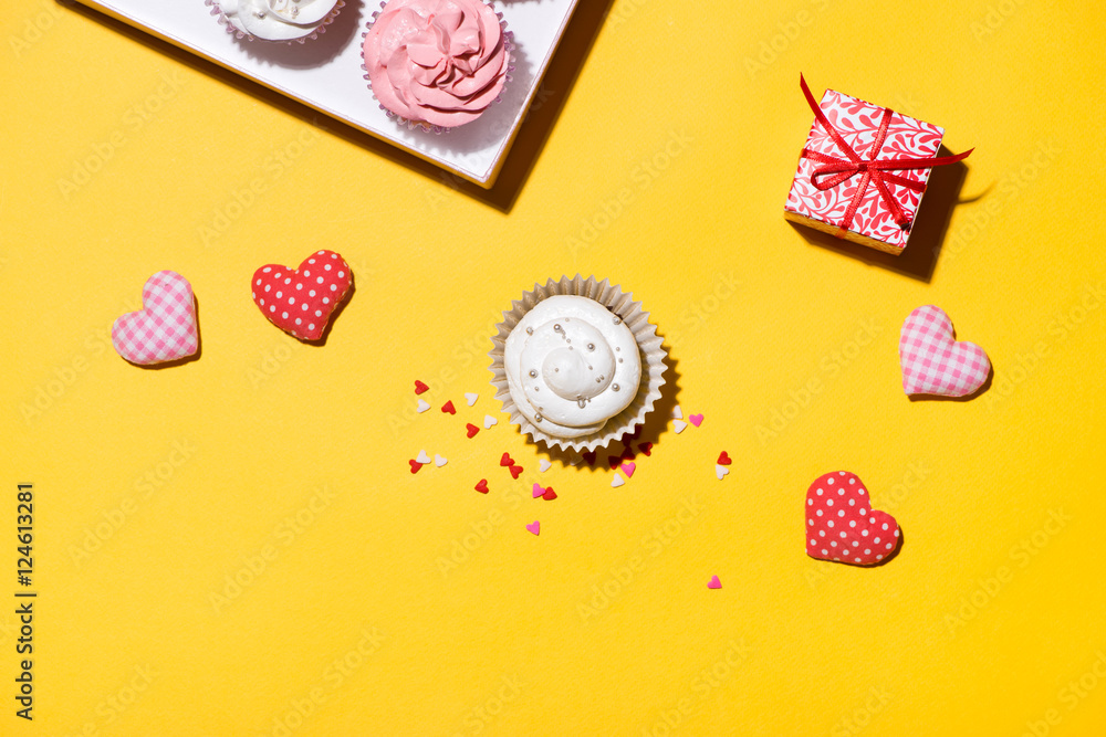 Delicious cupcake with paper box on yellow background