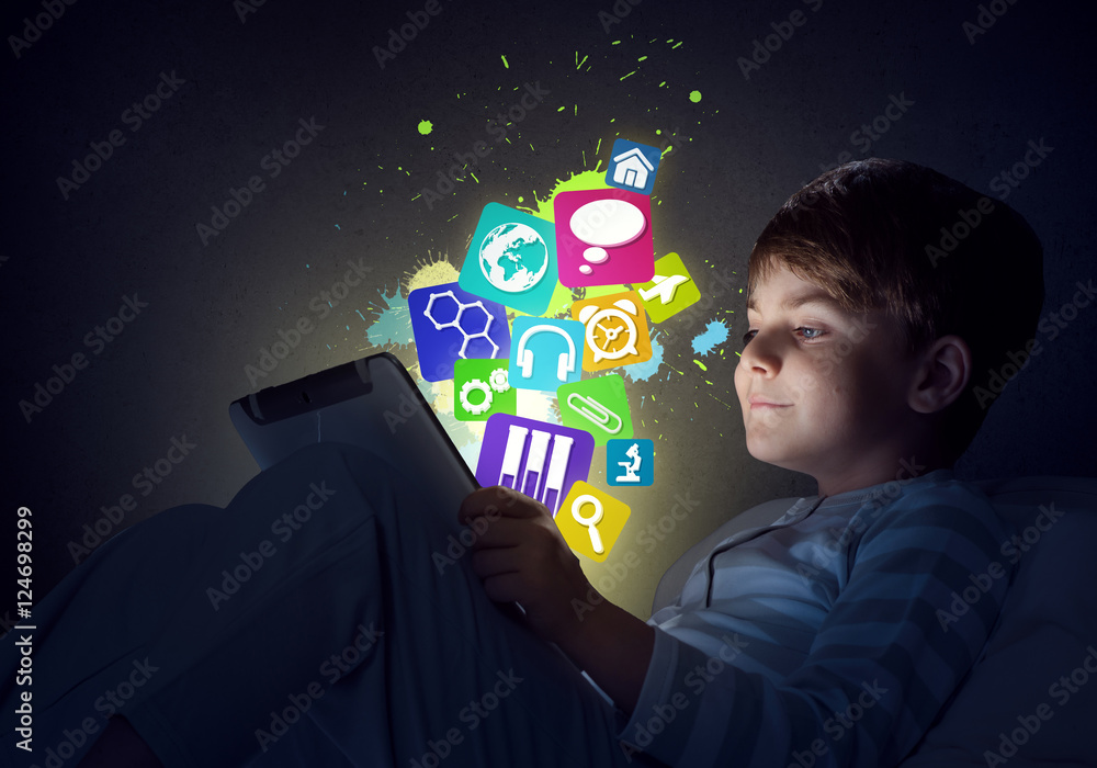 Boy with tablet in his bed