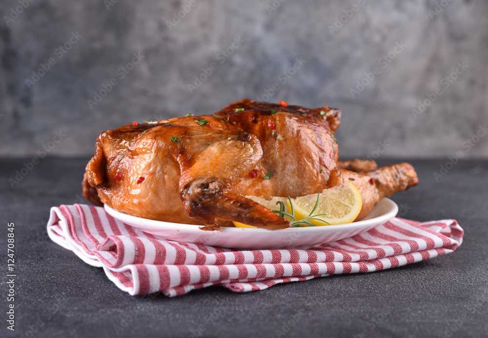 Chicken roasted on red napkin. black table. Front view.