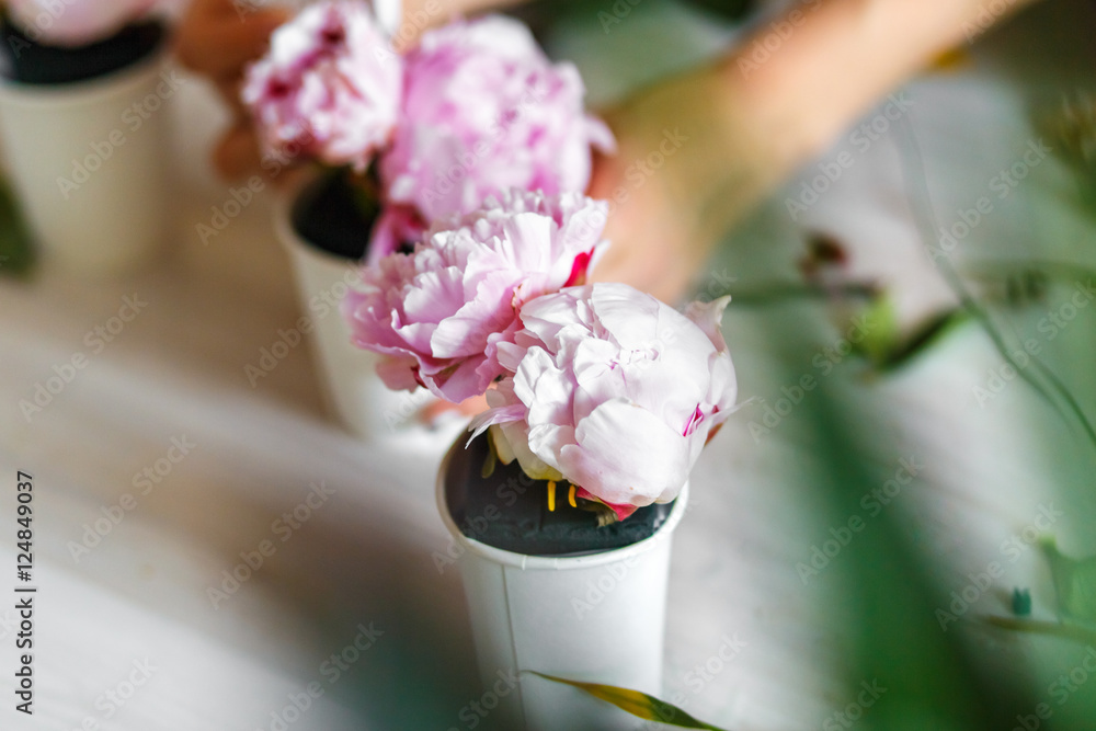 Florist making a bouguet of peonies