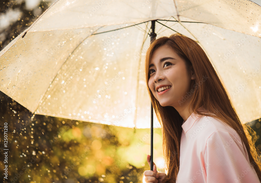 亚洲女人在等雨，她有一把伞。