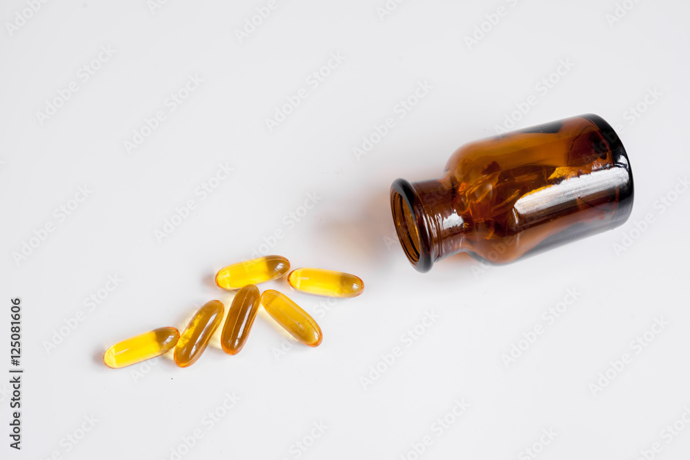 fish oil pills glass bottle on white background top view