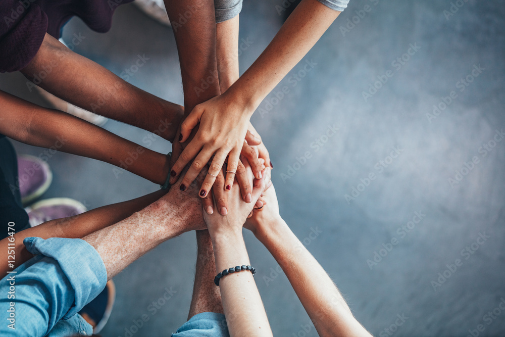 Stack of hands showing unity and teamwork