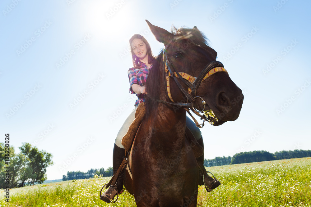 Portrait of young woman training riding a horse