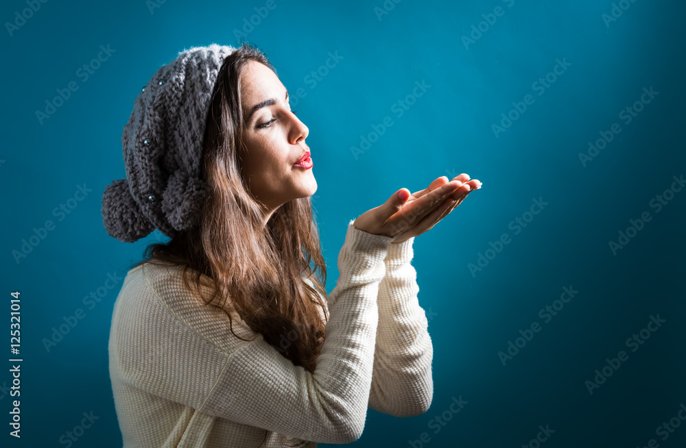 Happy young woman blowing a kiss