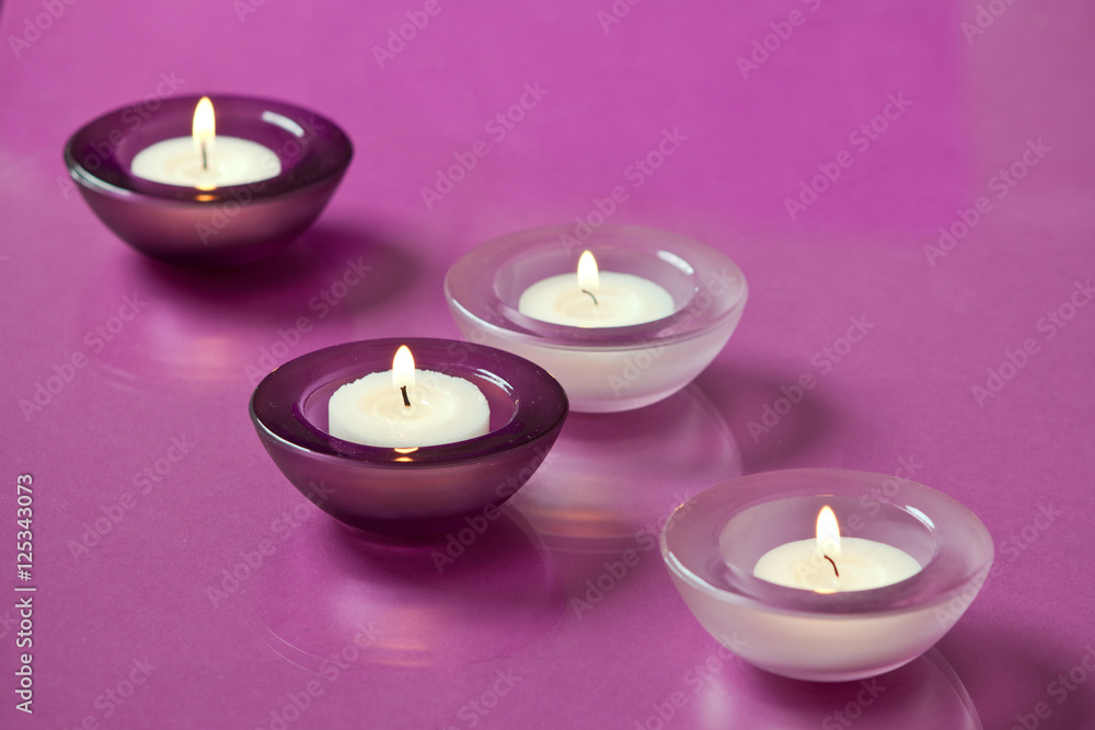 burning candles on purple background