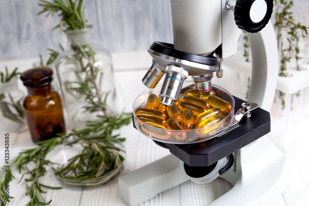 concept - check dietary supplements in laboratory on microscope