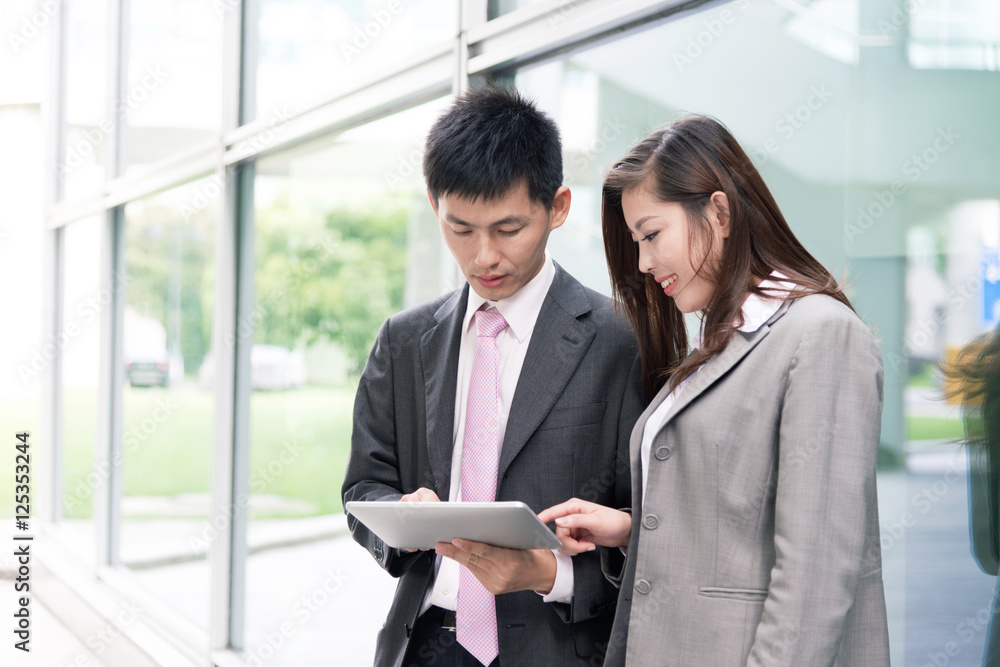 asian beautiful girl and businessman with tablet in modern hall