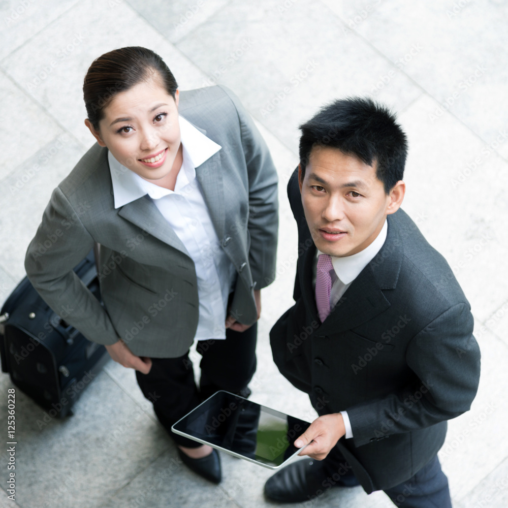 top view of woman and businessman with tablet and luggage