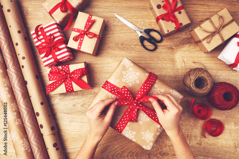 hand of woman  packs boxes with Christmas gifts