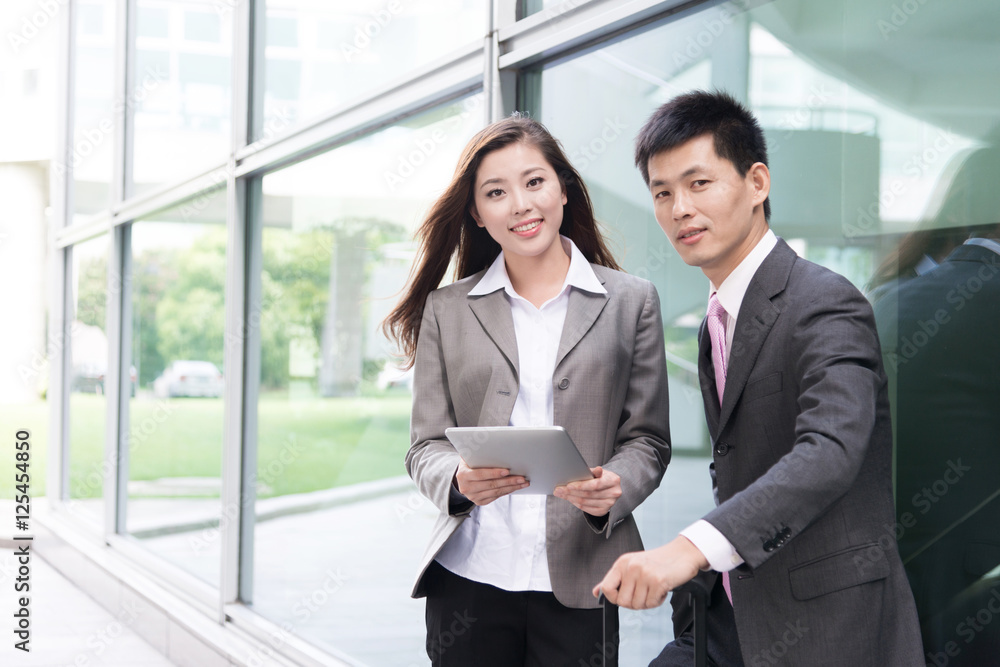 asian beautiful girl and businessman with tablet in modern hall