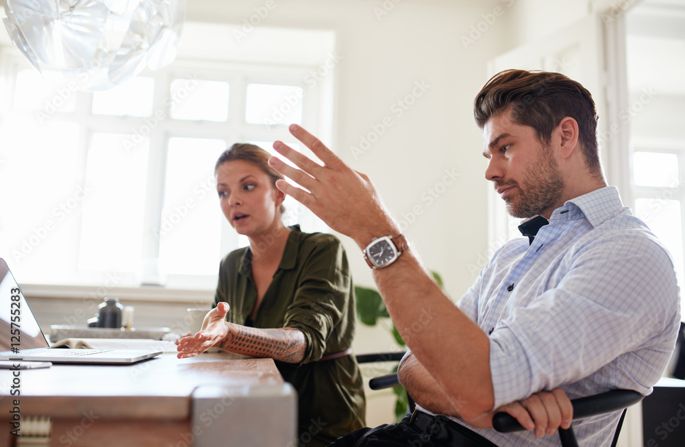 Young couple at home office discussing work