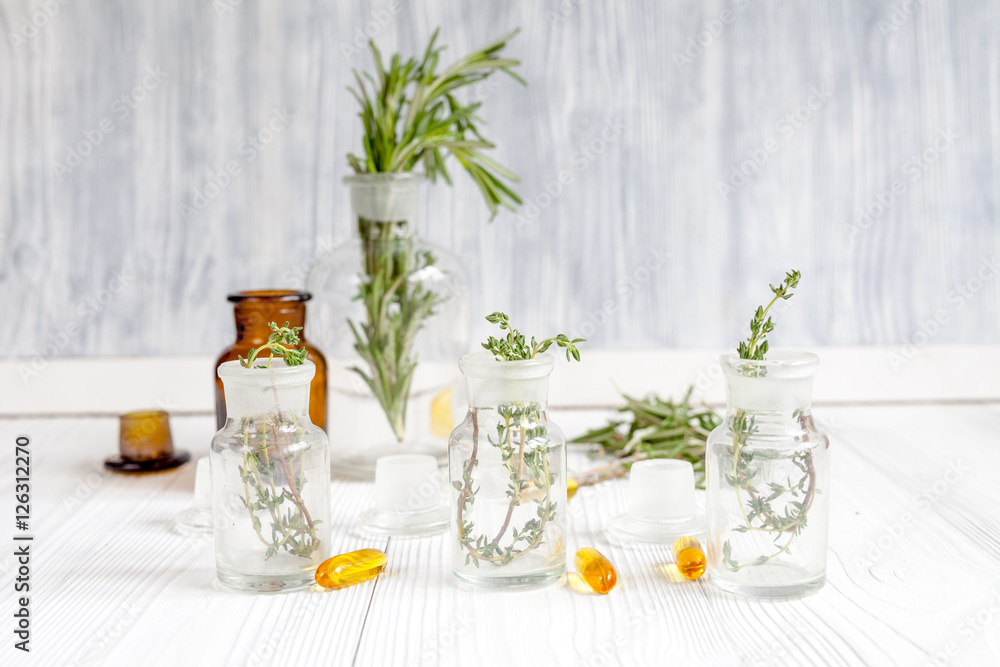 concept - natural medicine herbs in bottles on wooden background