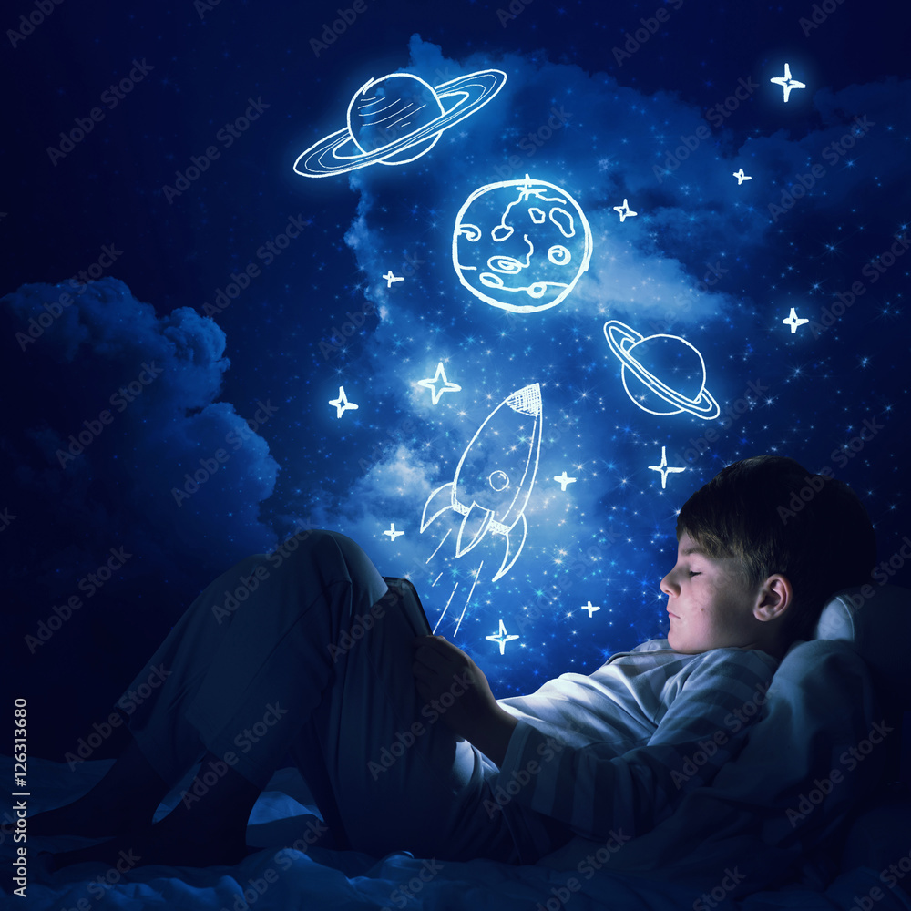 Boy with tablet in his bed