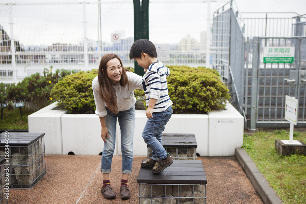 Mom and son are playing at the rooftop park