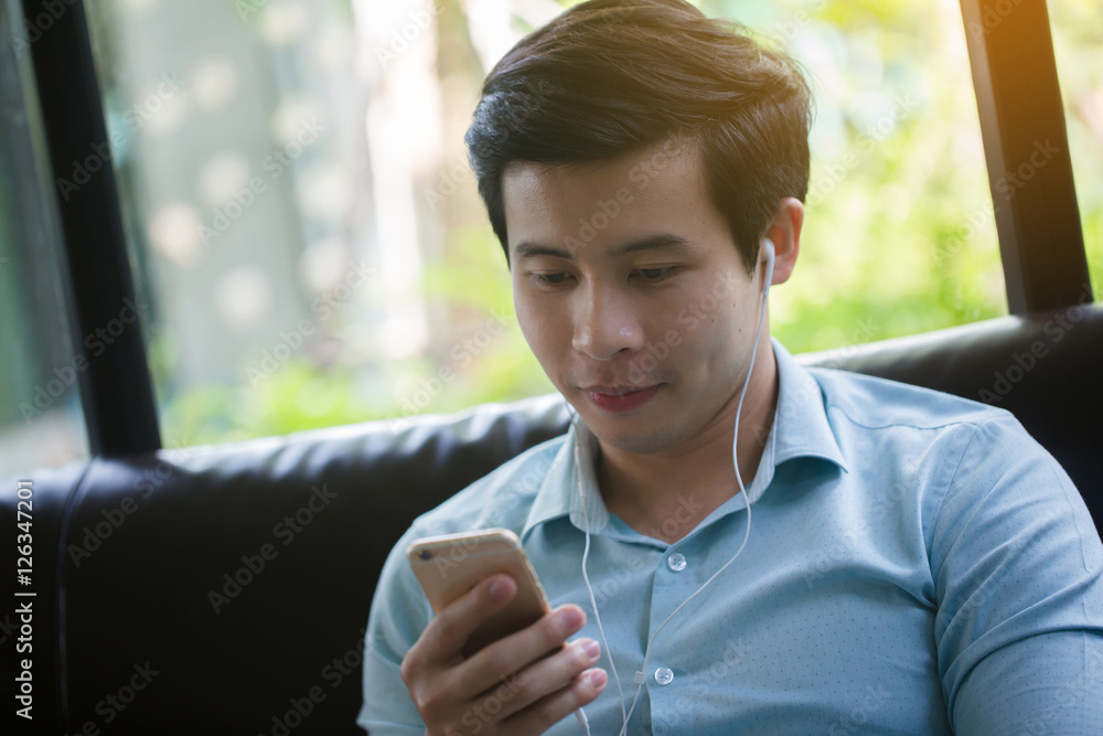 亚洲年轻男子在咖啡馆玩游戏在线智能手机