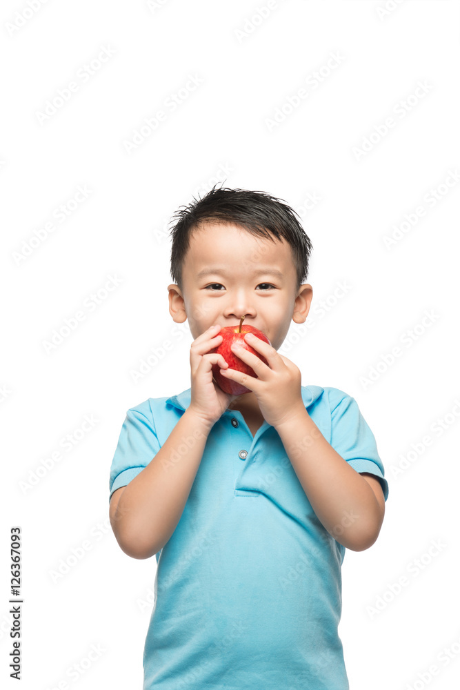 Asian baby boy holding and eating red apple, isolated on white