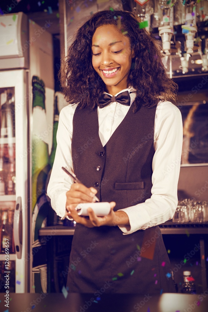 Composite image of cheerful bartender writing down order