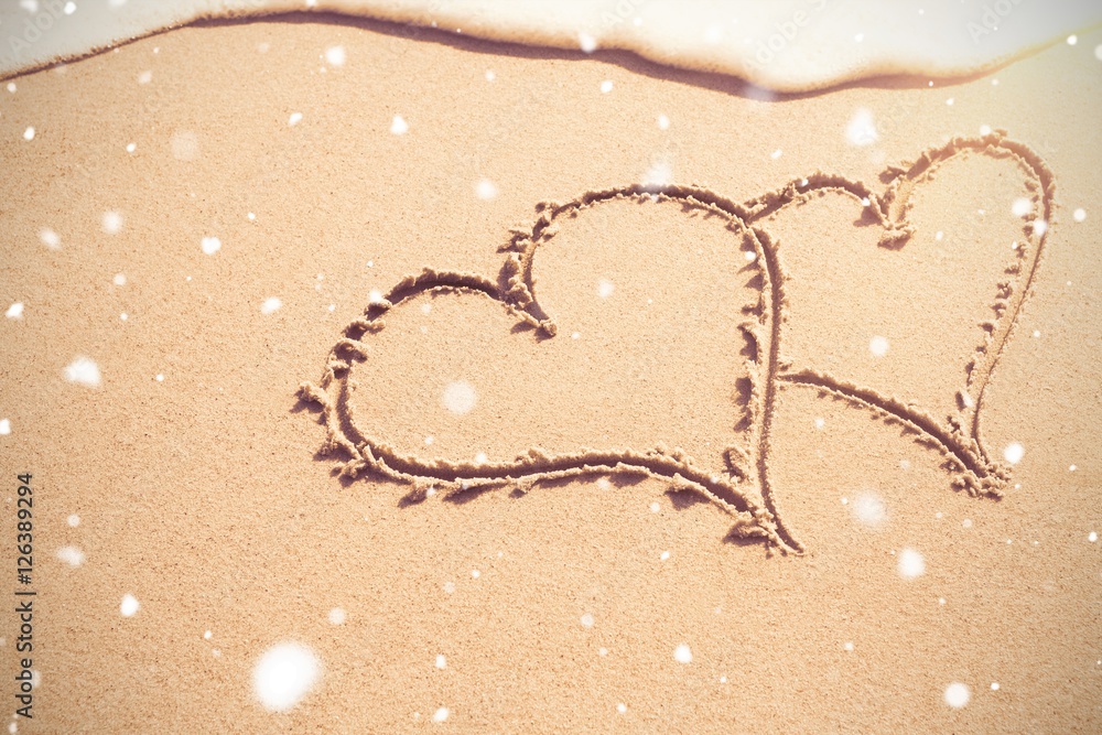 Two heart shapes drawn on sand