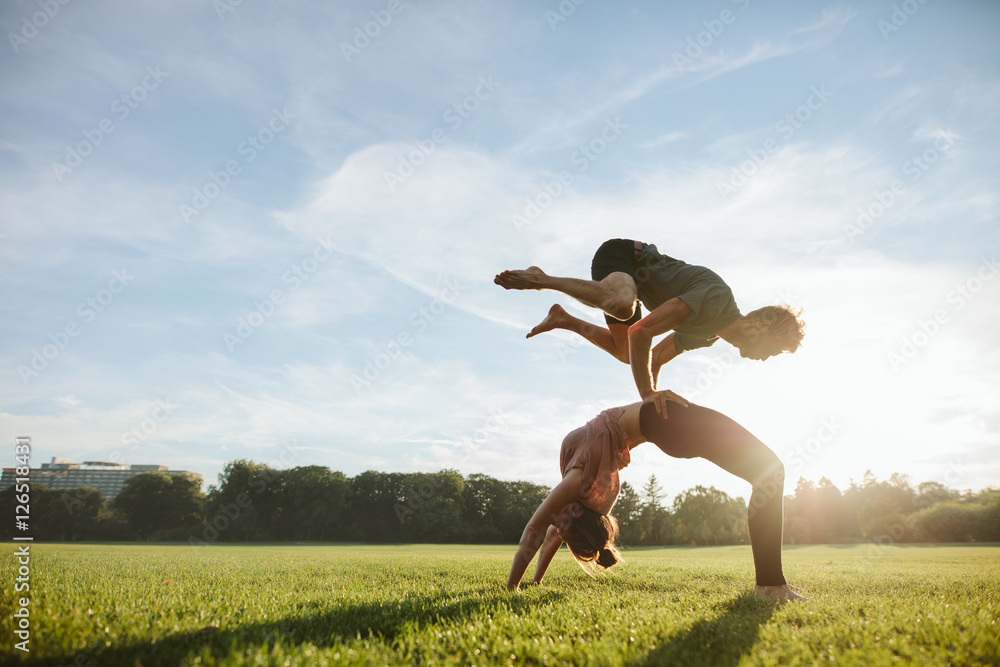 Strong young couple doing acroyoga workout