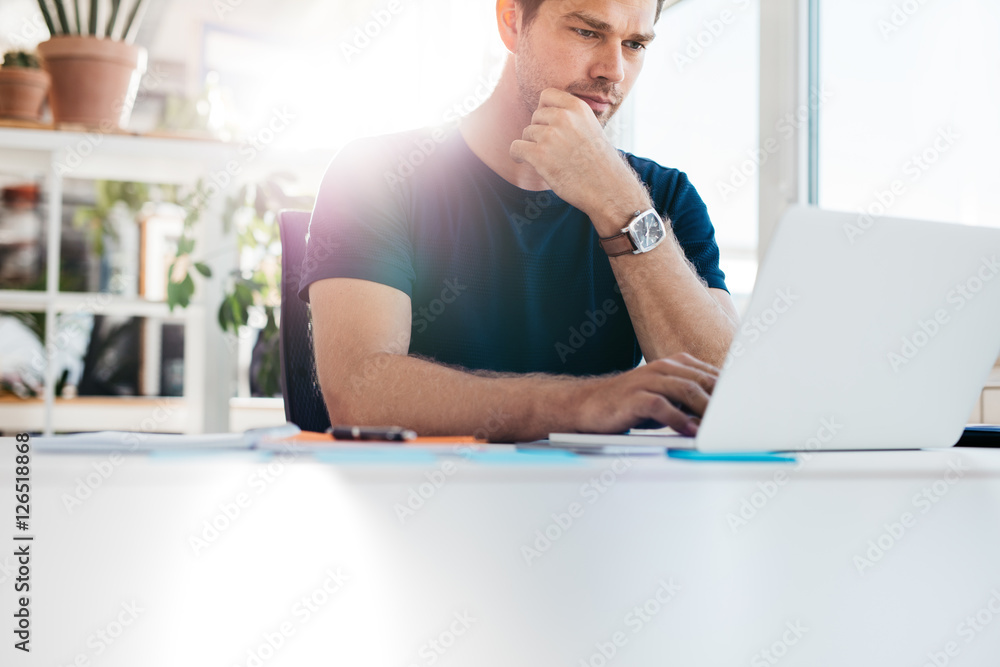 Young man at office working on laptop