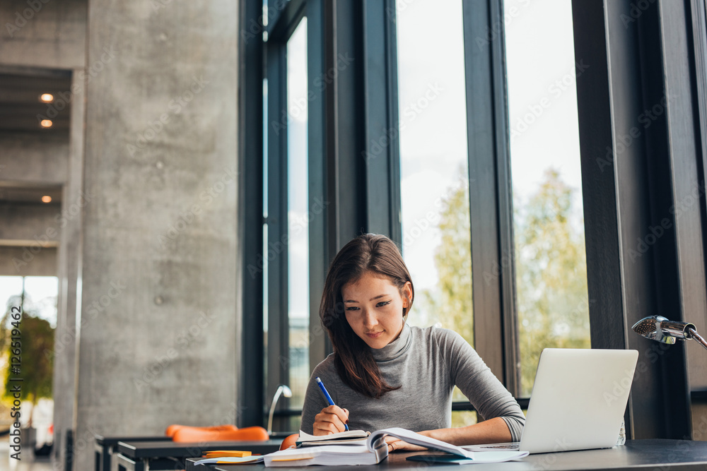 Young female student studying in library