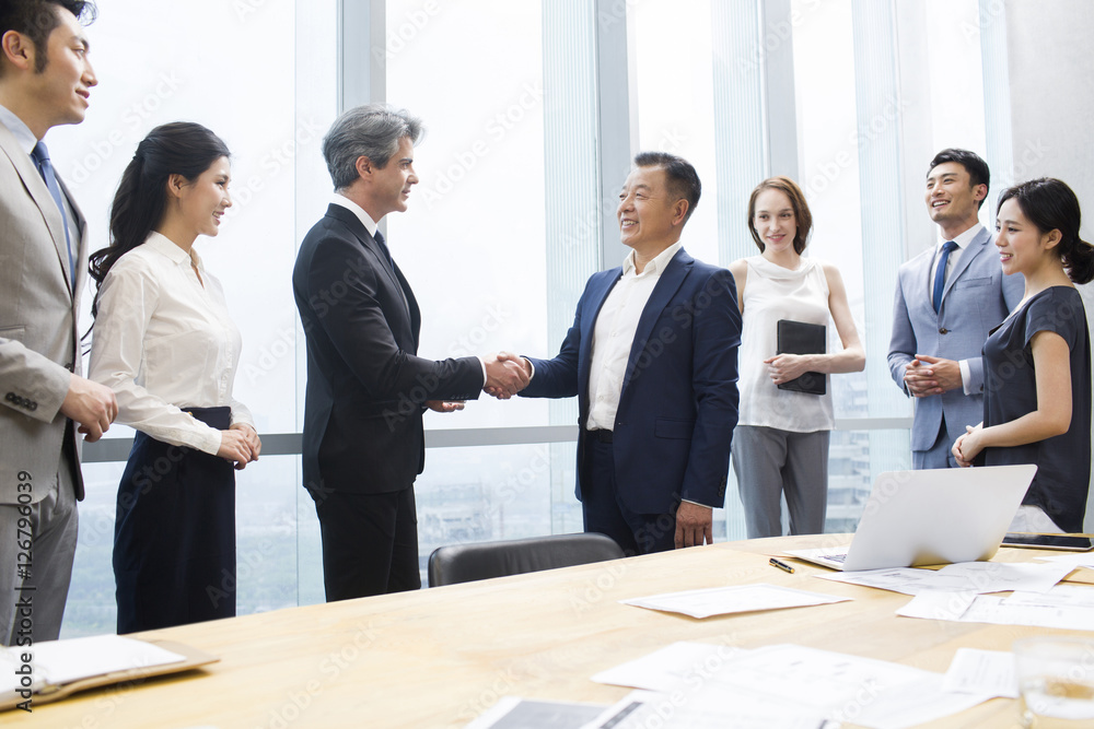 Businessmen shaking hands in meeting room