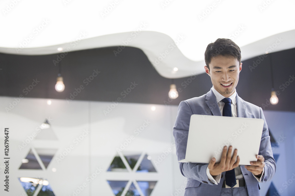 Young businessman working with laptop in office