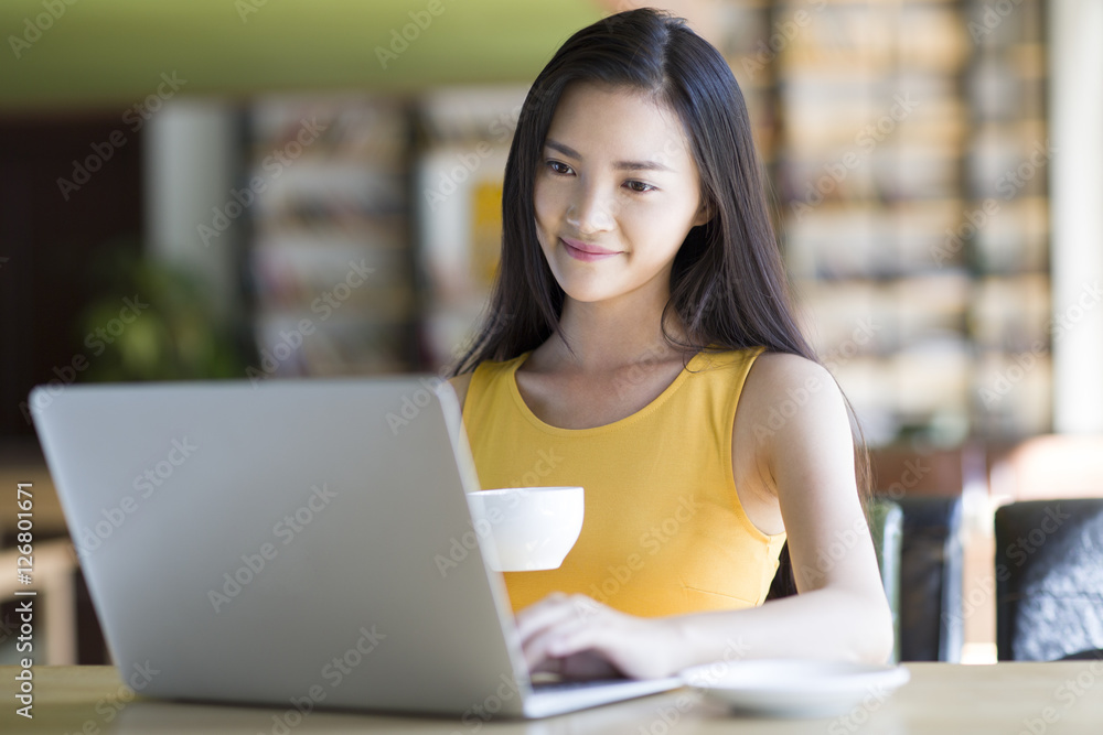 Young woman using laptop in cafe