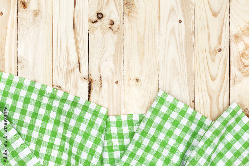 Green checkered tablecloth on wooden table, top view