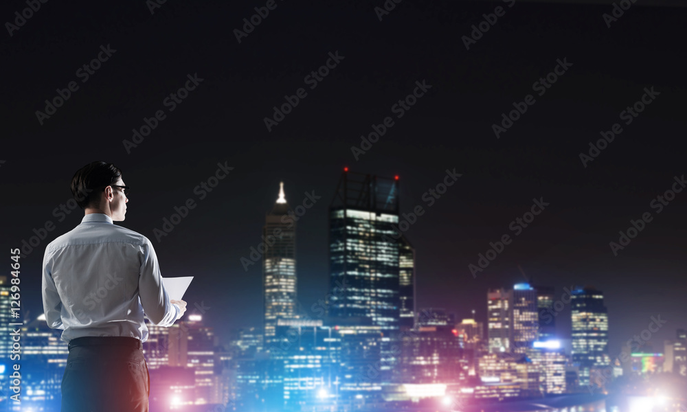 Businessman viewing night glowing city