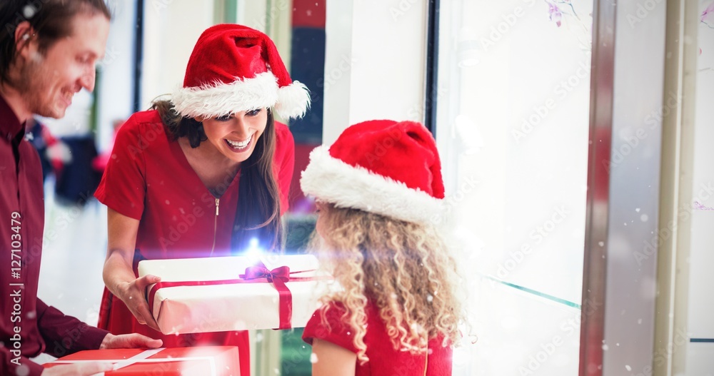 Composite image of parents giving christmas gifts to their daugh