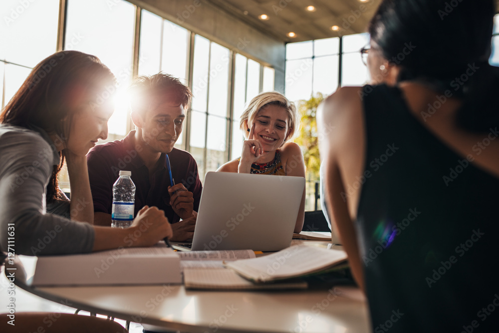 Students using laptop while sitting together in class