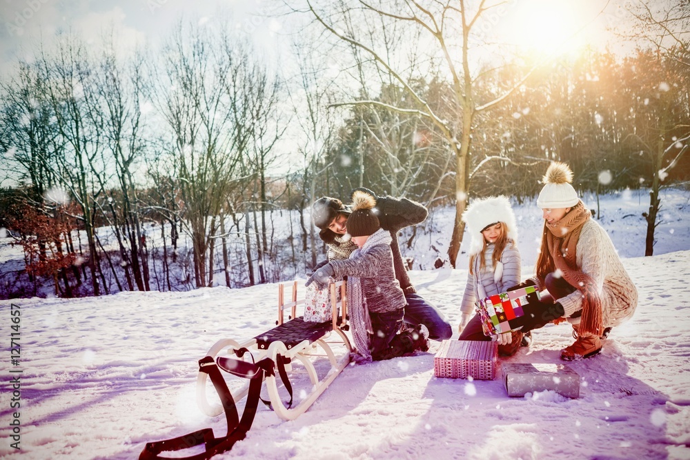 Composite image of family playing with sled