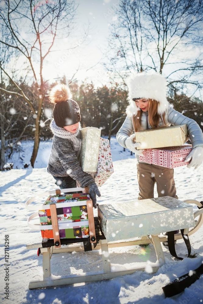 兄弟姐妹在雪橇上放礼物的合成图像