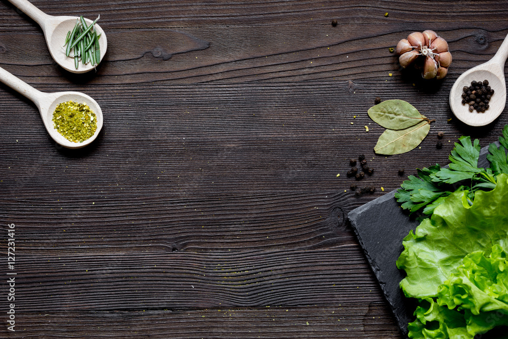 spices and fresh salad on dark wooden table top view