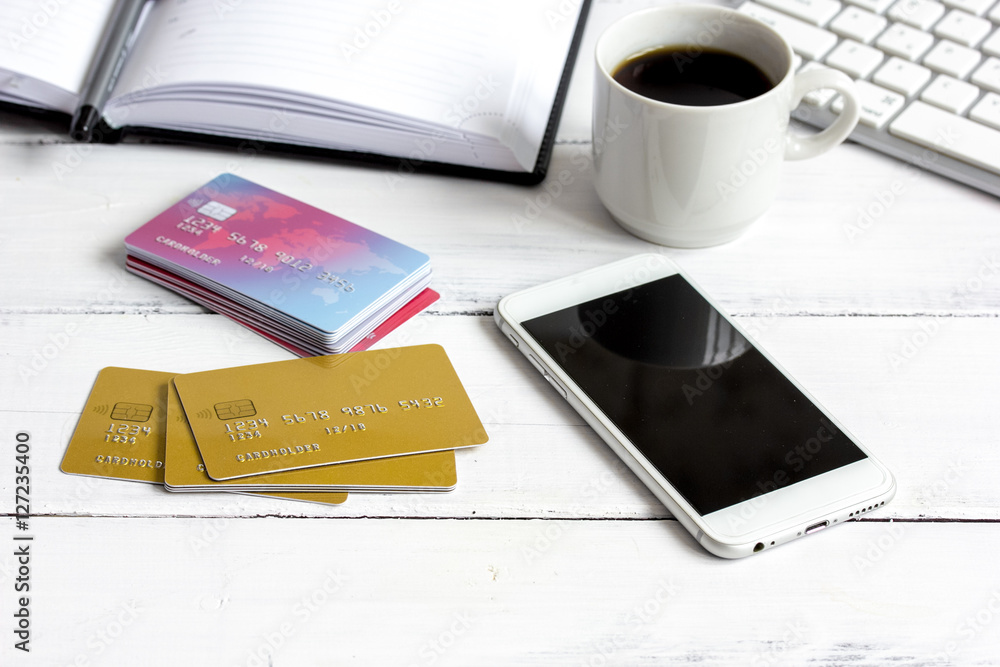 credit card, keyboard, smartphone and coffee cup on wooden background