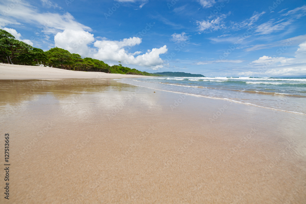 Waves sand beach and clouds sunny day